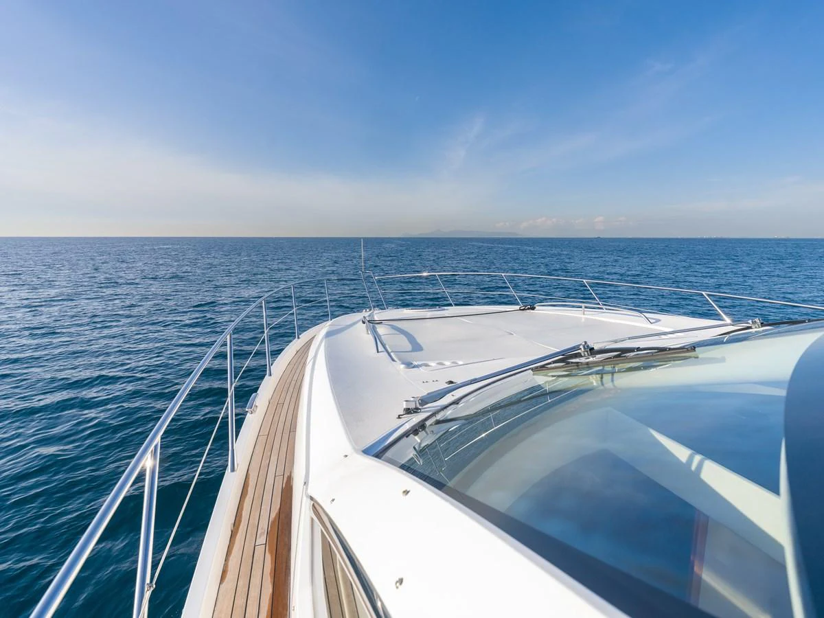 The yacht's sleek bow cuts through the calm, open sea under a clear blue sky. aboard M/Y MIEL Yacht for Sale