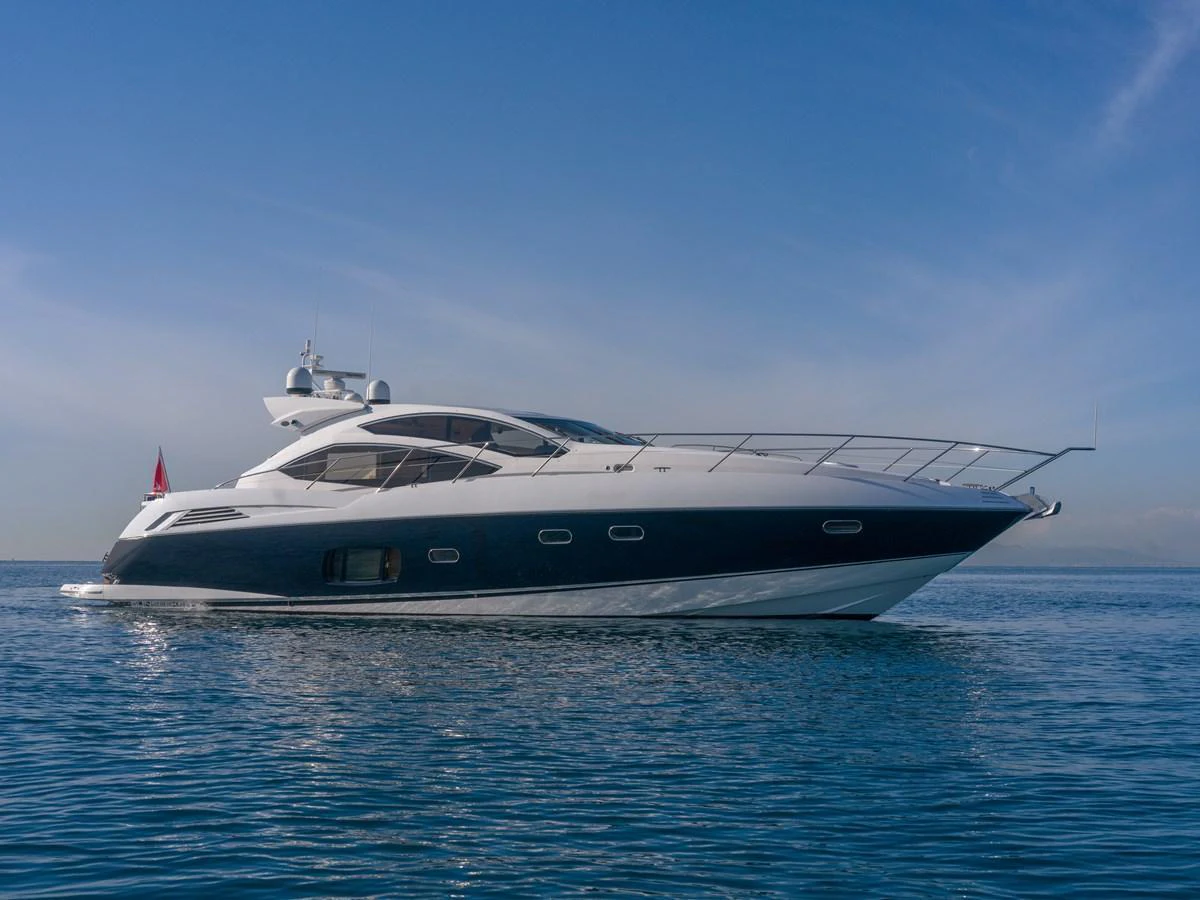 A sleek and modern yacht glides gracefully on calm blue waters under a clear sky. aboard M/Y MIEL Yacht for Sale