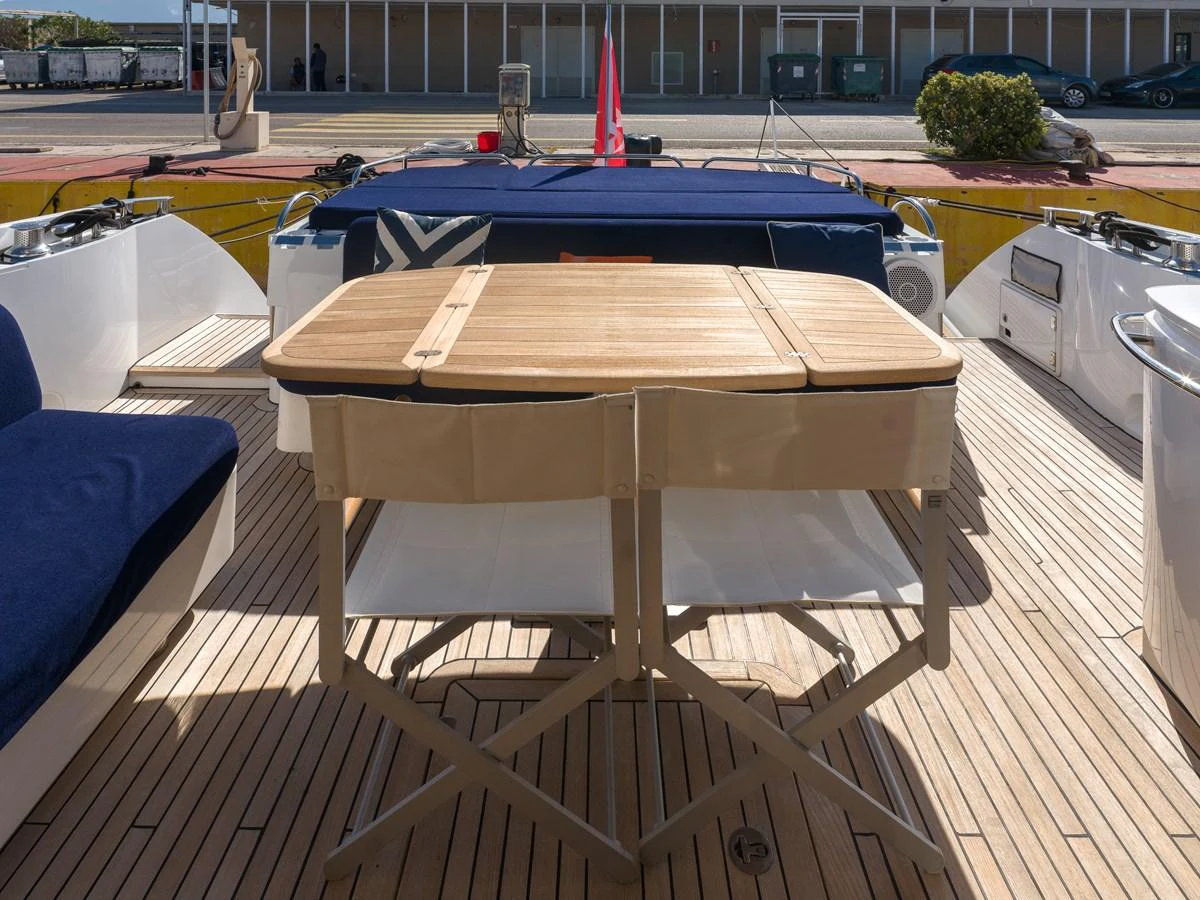 The aft deck features a comfortable seating area with a wooden table, perfect for outdoor dining and relaxation. aboard M/Y MIEL Yacht for Sale