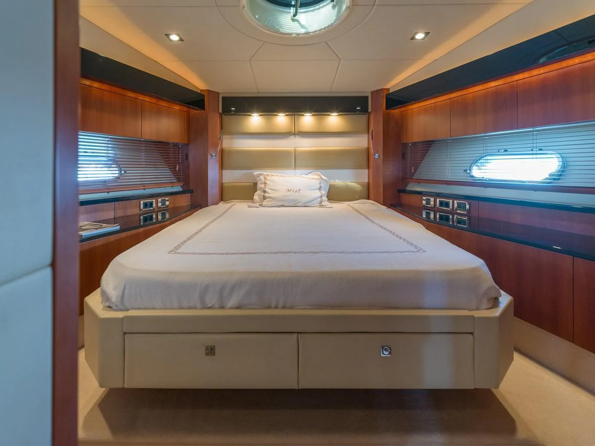 A luxurious stateroom featuring a comfortable bed and elegant wood paneling. aboard M/Y MIEL Yacht for Sale