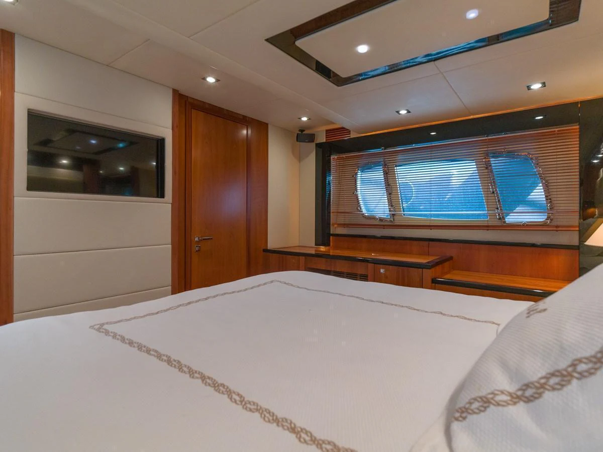 The stateroom features a cozy bed, wooden accents, and ample natural light through large windows. aboard M/Y MIEL Yacht for Sale