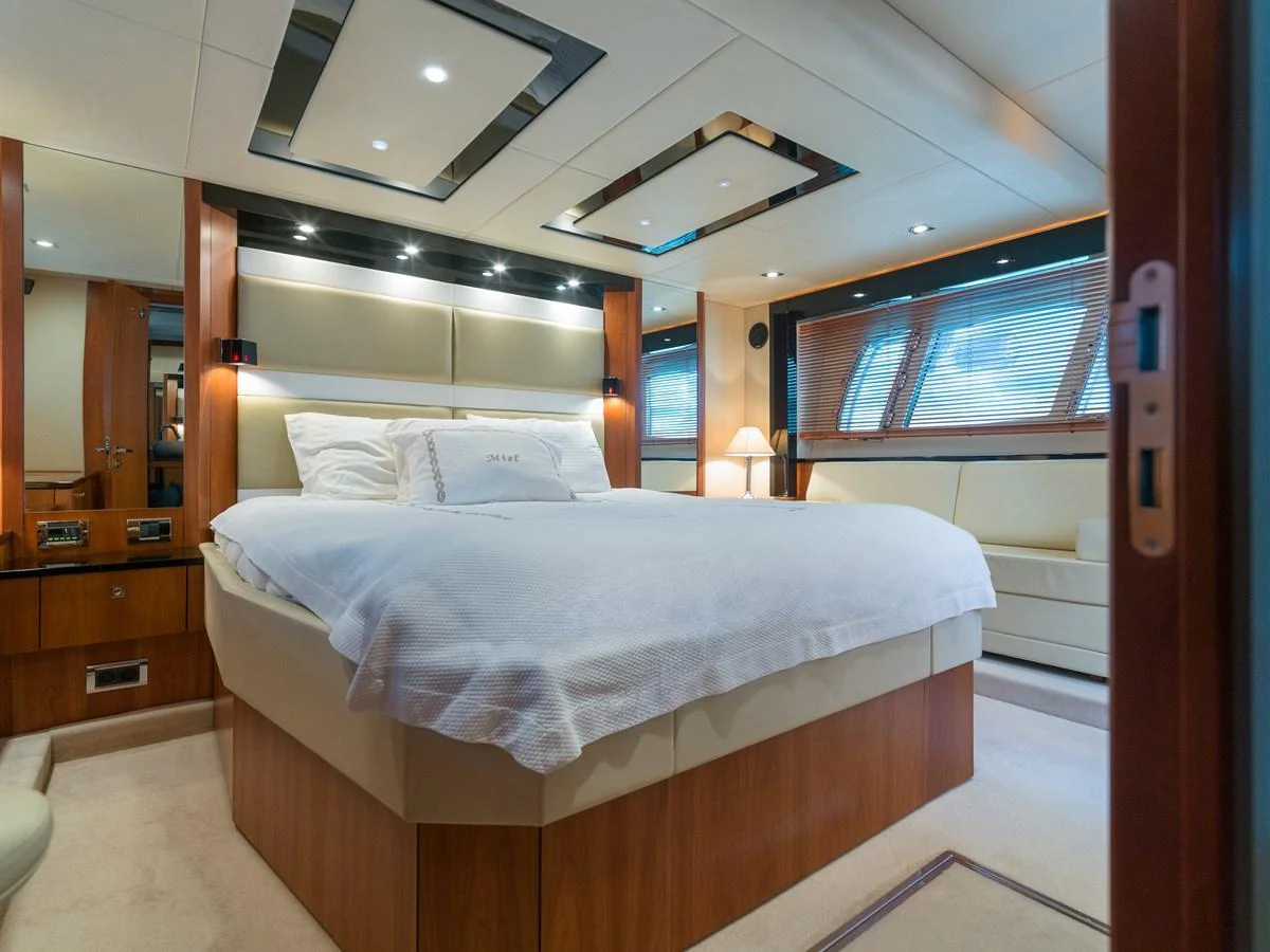 The master stateroom features a spacious bed, elegant wood finishes, and ample natural light. aboard M/Y MIEL Yacht for Sale