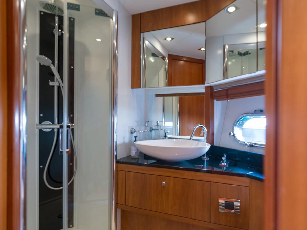 The yacht's bathroom features a sleek design with a modern sink and a glass-enclosed shower. aboard M/Y MIEL Yacht for Sale