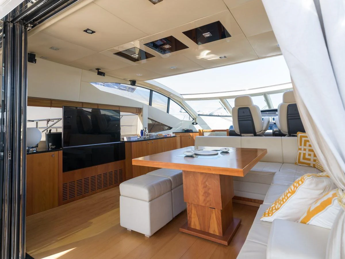 The salon features a modern design with a comfortable seating area and a stylish dining table. aboard M/Y MIEL Yacht for Sale