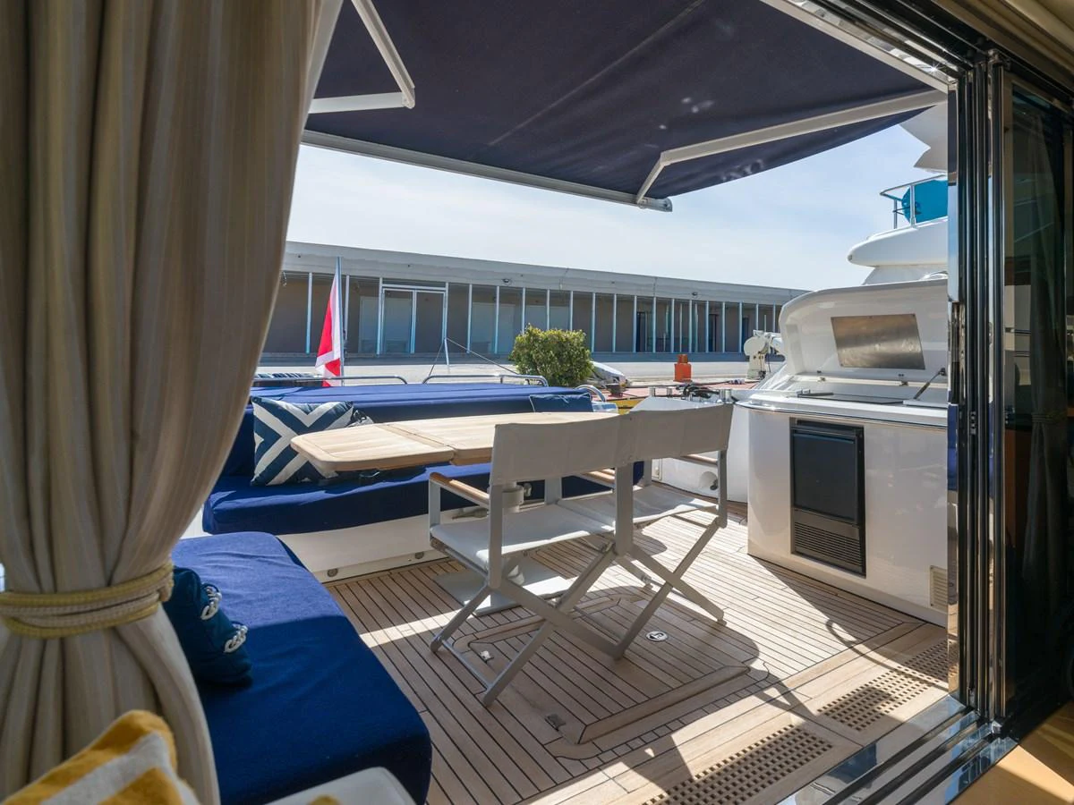 The aft deck features comfortable seating and a dining area under a retractable awning. aboard M/Y MIEL Yacht for Sale