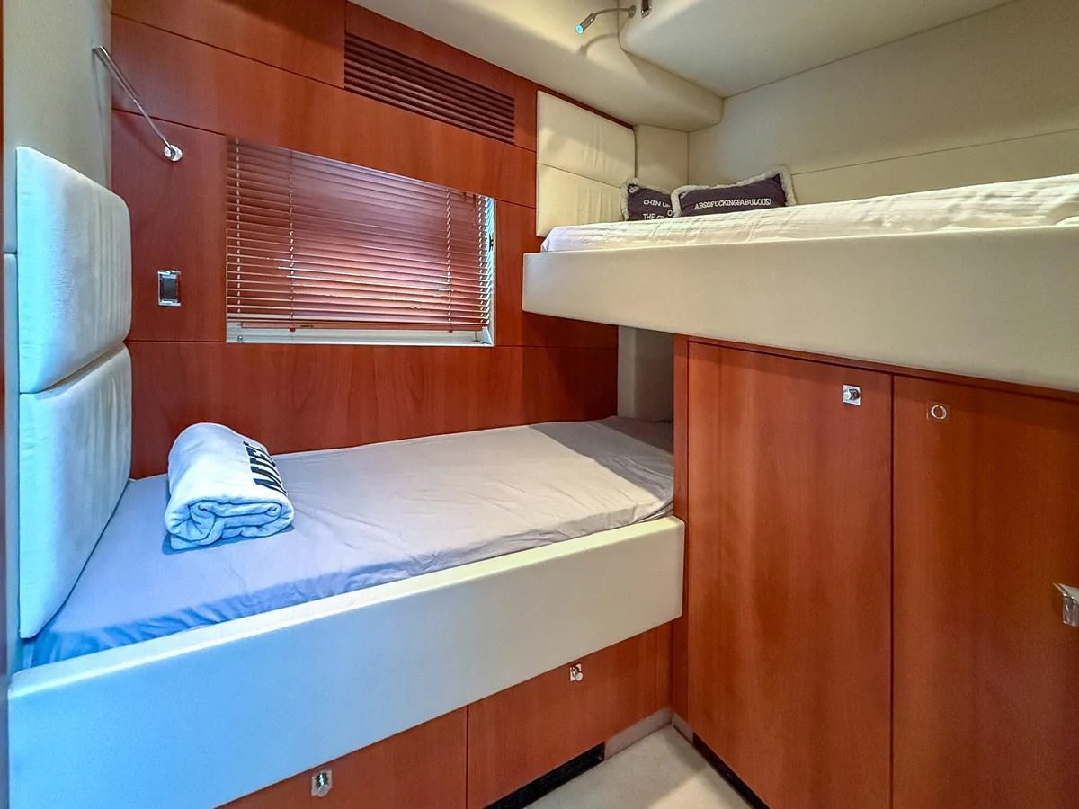 The guest cabin features cozy twin bunk beds with warm wooden accents. aboard M/Y MIEL Yacht for Sale