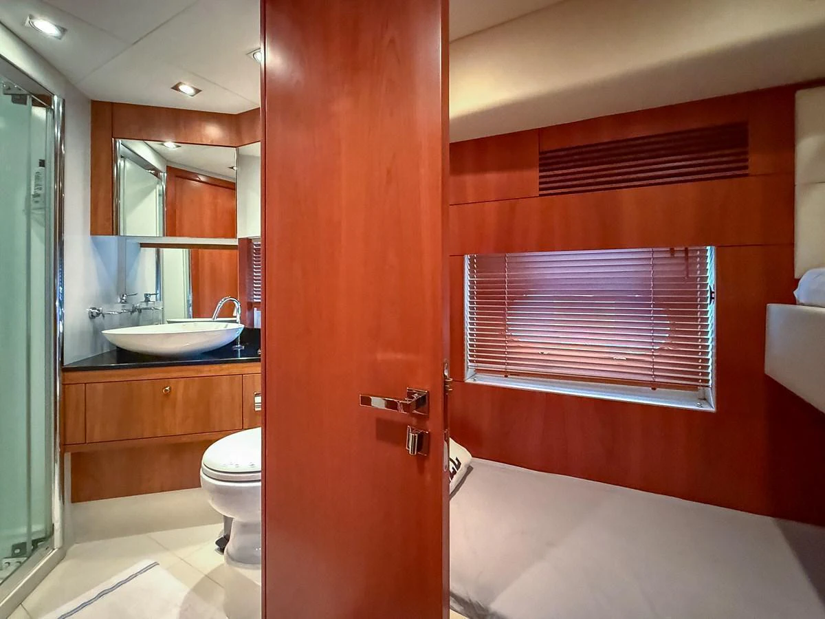 The guest cabin features a cozy bed, wooden cabinetry, and an en-suite bathroom with modern fixtures. aboard M/Y MIEL Yacht for Sale