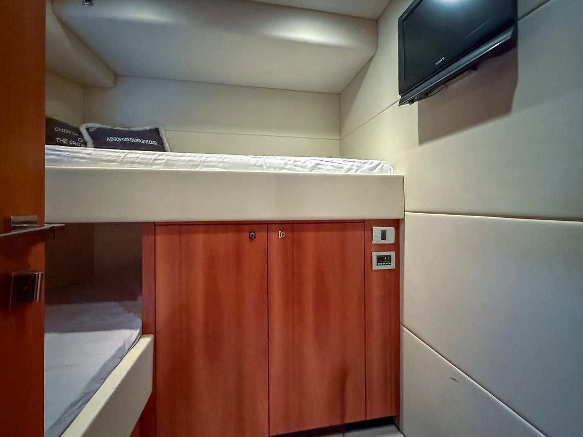 A cozy guest cabin featuring a bunk bed and a wall-mounted television. aboard M/Y MIEL Yacht for Sale