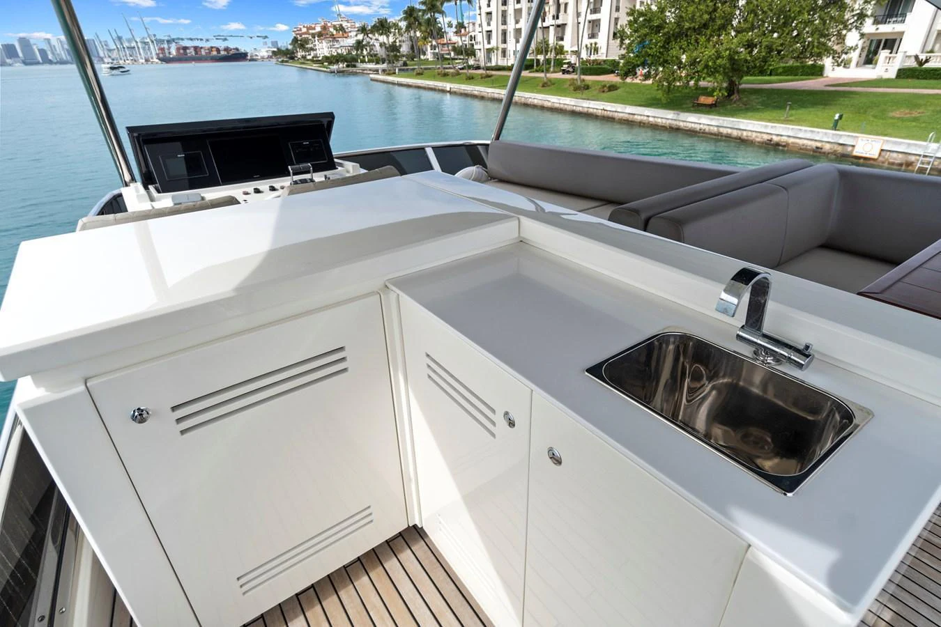 The flybridge features a sleek wet bar with a stainless steel sink and ample counter space, perfect for outdoor entertaining. aboard JESSEA Yacht for Sale