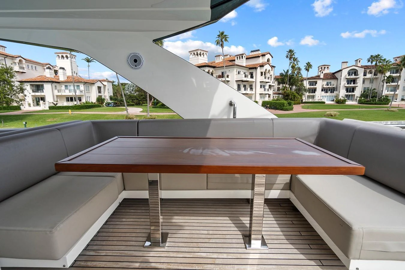 The aft deck features a stylish dining area with a wooden table and cushioned seating, perfect for alfresco meals. aboard JESSEA Yacht for Sale