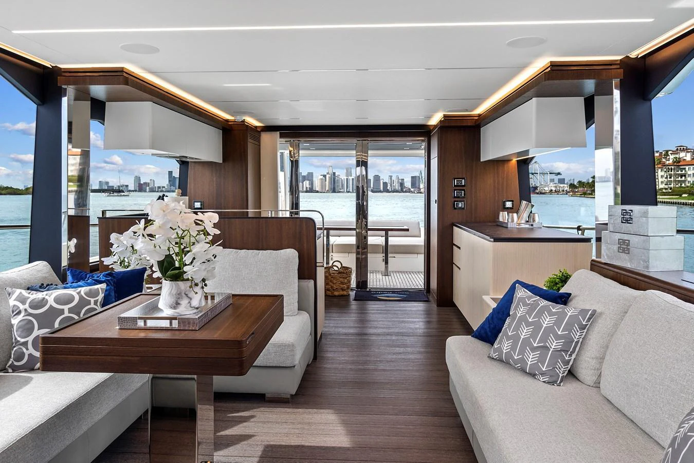 The yacht's salon features elegant seating with panoramic views of the water and cityscape. aboard JESSEA Yacht for Sale