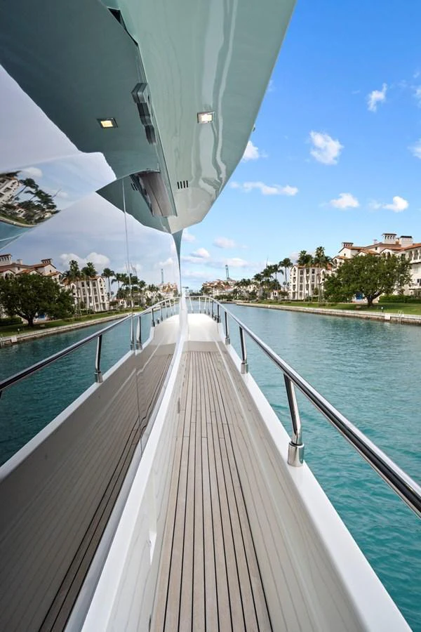 The sleek side deck of the yacht offers a serene view of the surrounding waters and nearby buildings. aboard JESSEA Yacht for Sale