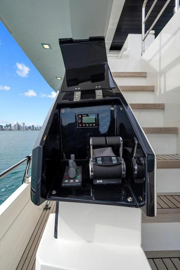 This image showcases the helm station with modern controls and a view of the water and city skyline. aboard JESSEA Yacht for Sale