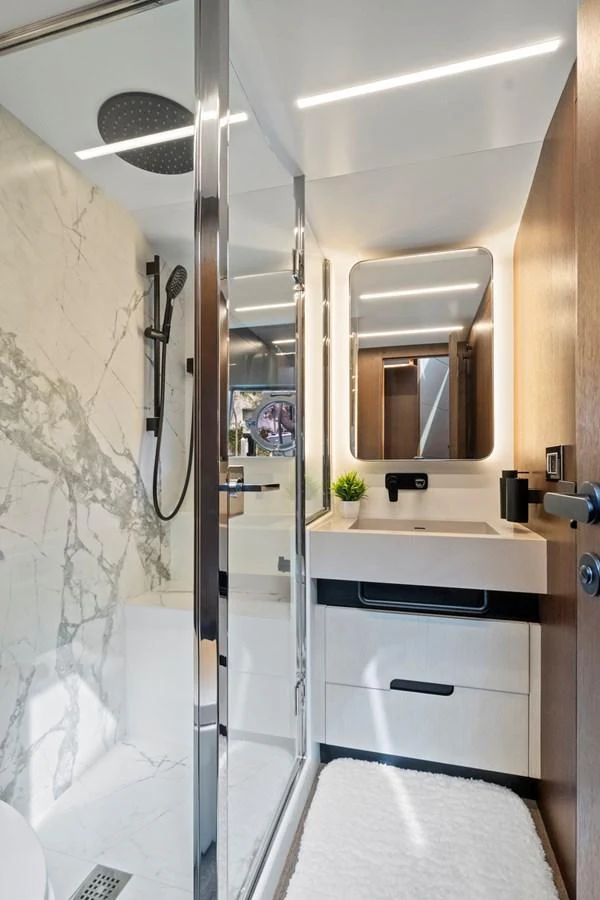 The yacht's bathroom features a modern design with a marble shower and sleek fixtures. aboard JESSEA Yacht for Sale
