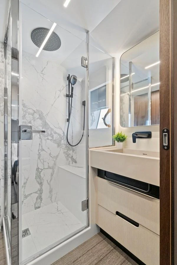 The yacht's bathroom features a modern shower with marble accents and sleek fixtures. aboard JESSEA Yacht for Sale