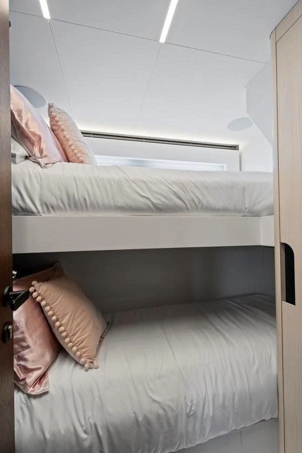 The cozy bunk cabin features neatly arranged beds with soft pillows, perfect for a restful sleep. aboard JESSEA Yacht for Sale