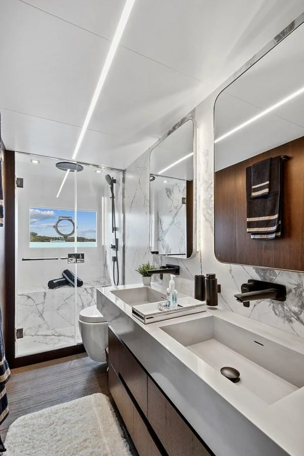 The yacht's bathroom features modern fixtures, a double sink, and a spacious shower with a view. aboard JESSEA Yacht for Sale