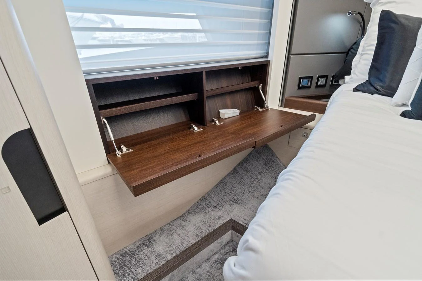 The image showcases a luxurious stateroom with a fold-out desk and modern decor. aboard JESSEA Yacht for Sale