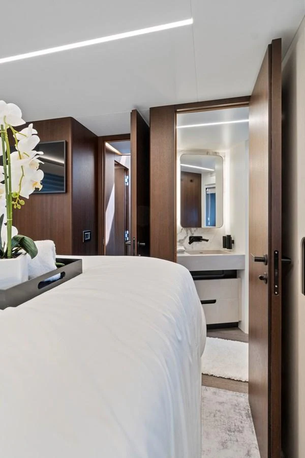 A luxurious stateroom featuring a plush bed and an ensuite bathroom with modern fixtures. aboard JESSEA Yacht for Sale