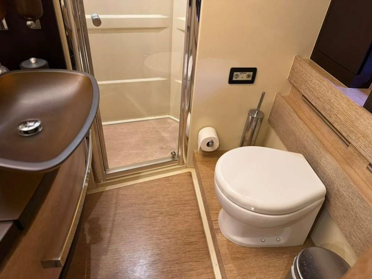 The yacht's bathroom features a modern design with a sleek sink, toilet, and enclosed shower. aboard TARKAN Yacht for Sale