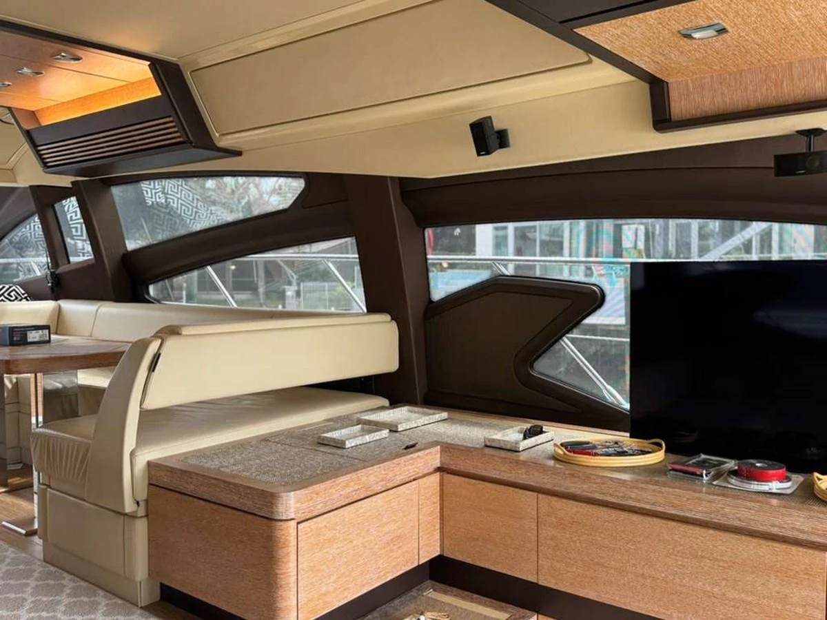The salon features a comfortable seating area with a modern entertainment system and elegant wooden finishes. aboard TARKAN Yacht for Sale