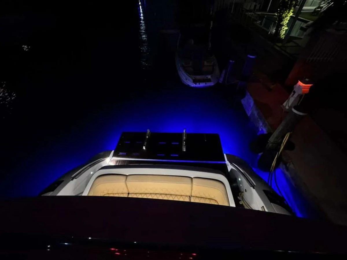 The yacht's stern is illuminated with blue underwater lights, creating a striking visual effect at night. aboard TARKAN Yacht for Sale