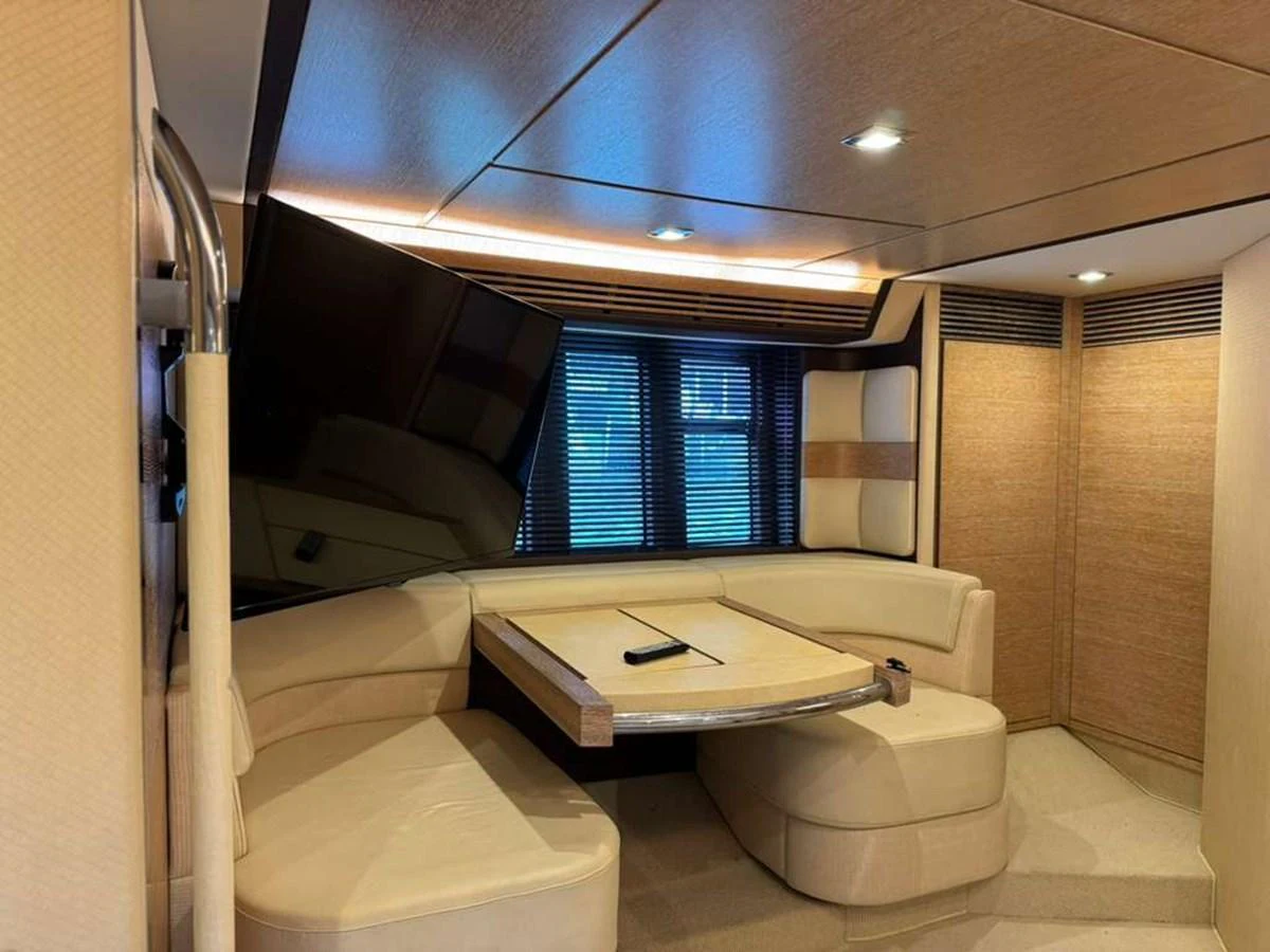 The yacht's dining area features a cozy seating arrangement with a modern table and ample natural light. aboard TARKAN Yacht for Sale