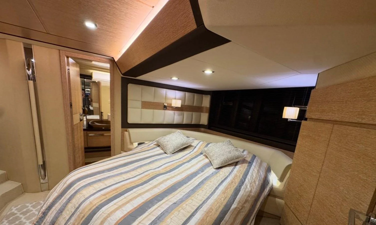 The stateroom features a cozy double bed with elegant lighting and modern decor. aboard TARKAN Yacht for Sale
