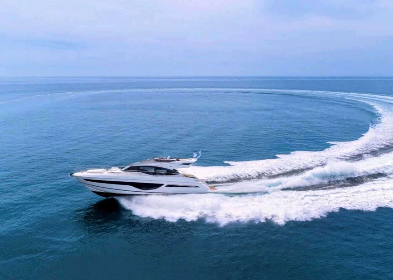 A sleek yacht glides swiftly across the open sea, leaving a trail of white wake behind. aboard BK ONE Yacht for Sale