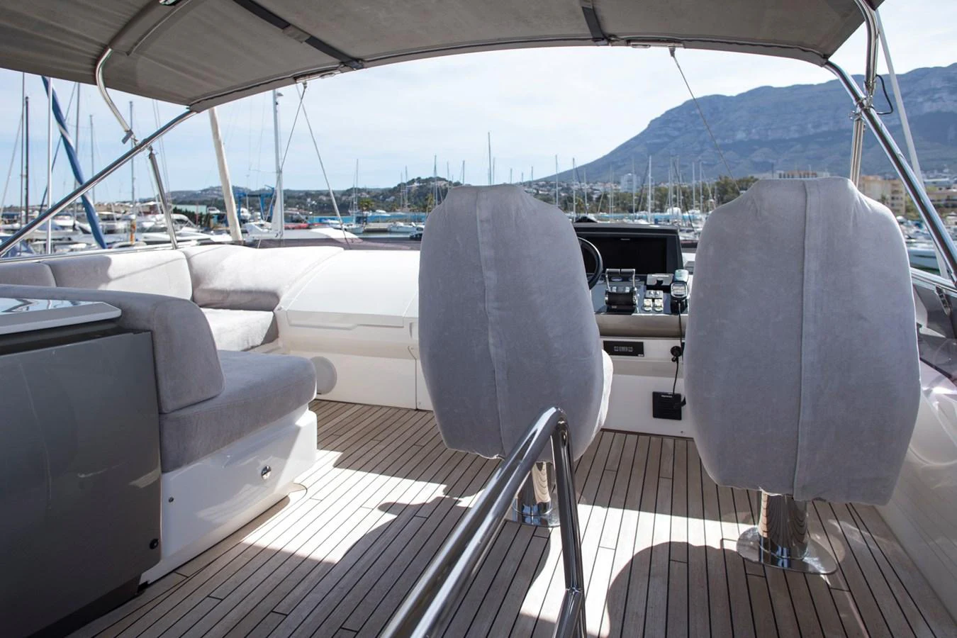 The helm area features comfortable seating and a sleek control panel, offering a commanding view of the marina. aboard BK ONE Yacht for Sale