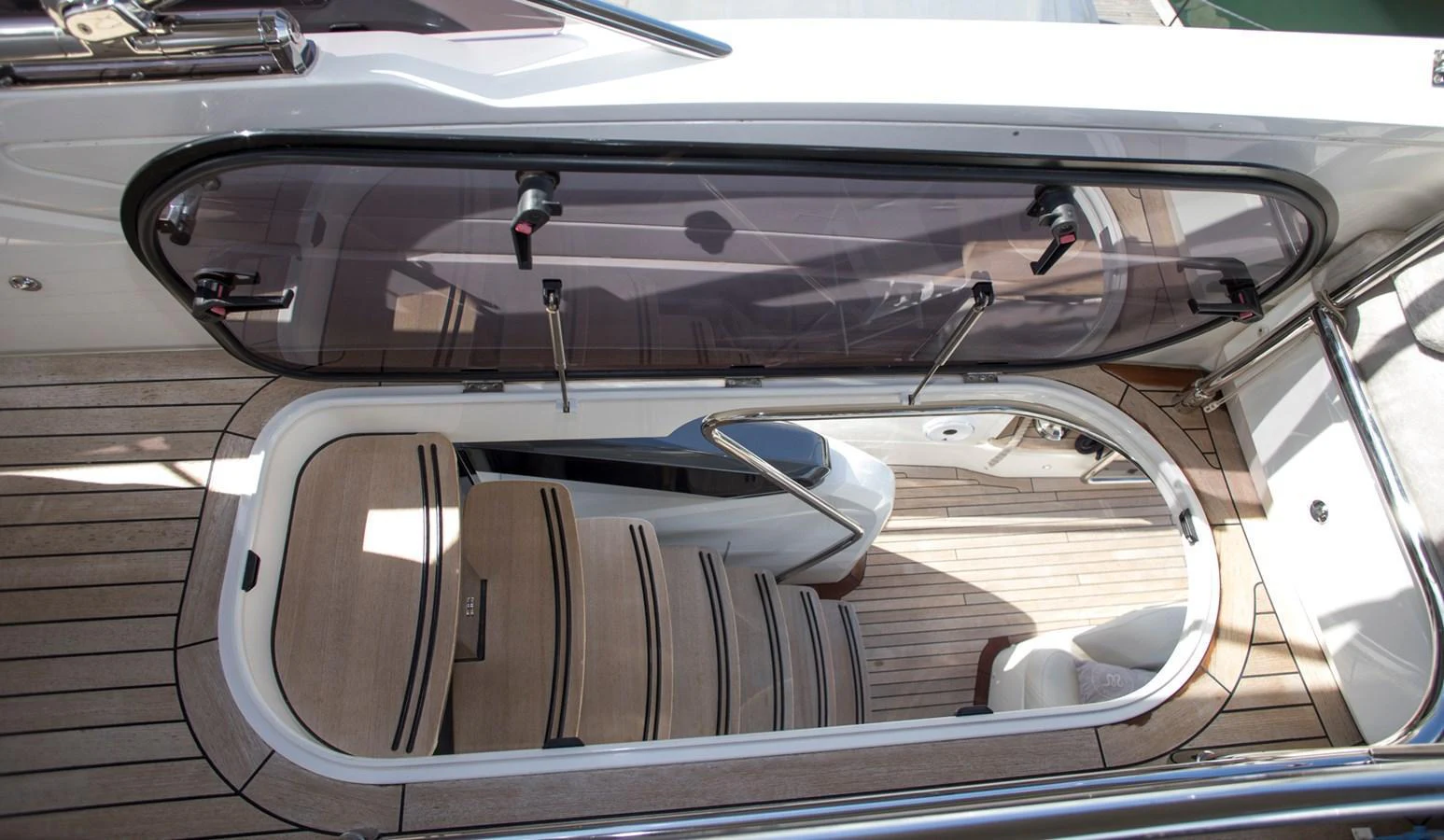 A sleek and modern staircase leads down into the yacht's interior, showcasing elegant wood finishes and a sophisticated design. aboard BK ONE Yacht for Sale