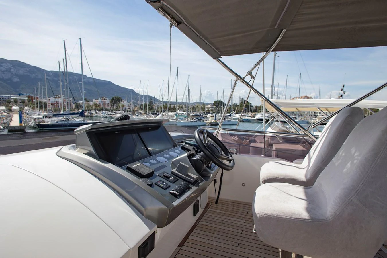The yacht's helm station offers a commanding view of the marina, with plush seating and advanced navigation controls. aboard BK ONE Yacht for Sale