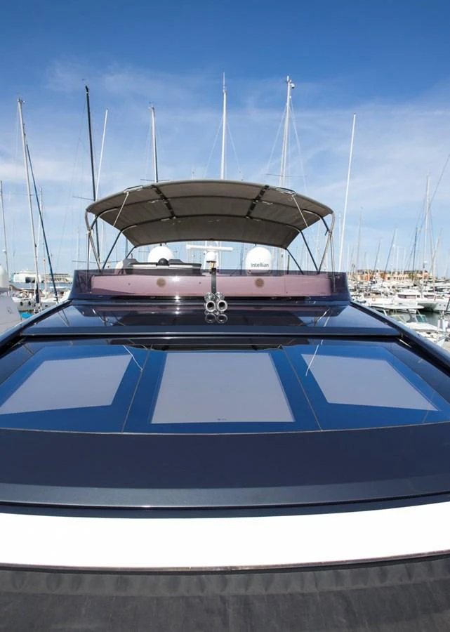 The yacht's sleek exterior features a modern design with expansive sunroof panels and a shaded upper deck. aboard BK ONE Yacht for Sale
