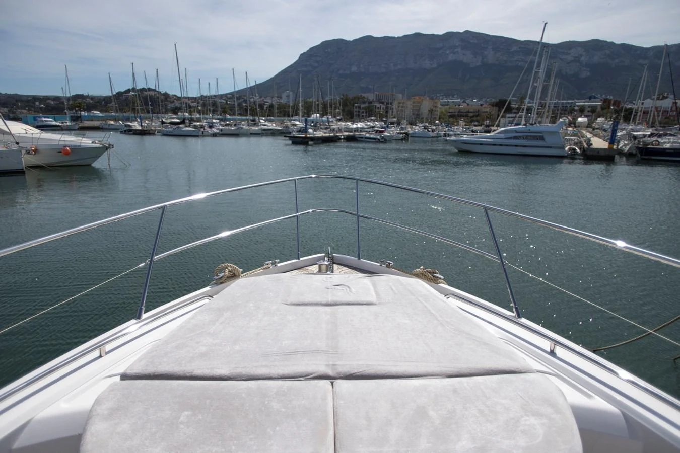 The yacht's bow offers a spacious sunbathing area with a scenic marina backdrop. aboard BK ONE Yacht for Sale