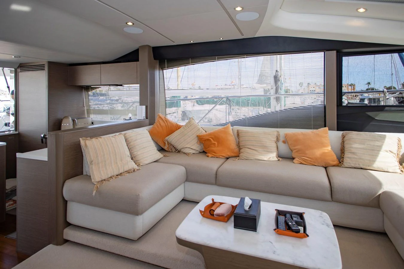 The salon features a comfortable seating area with large windows providing ample natural light and views of the marina. aboard BK ONE Yacht for Sale