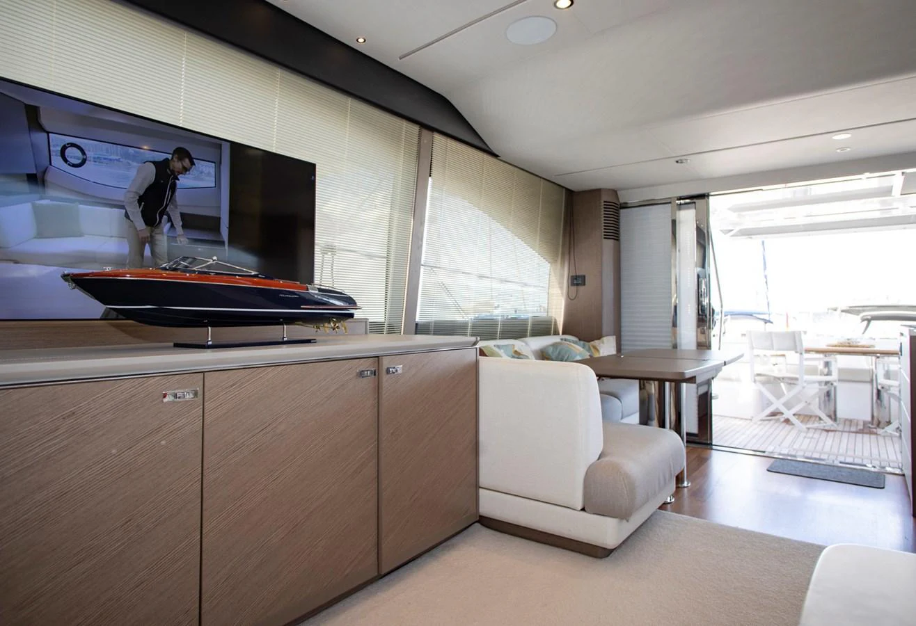 The salon features a comfortable seating area with a television and access to the aft deck. aboard BK ONE Yacht for Sale