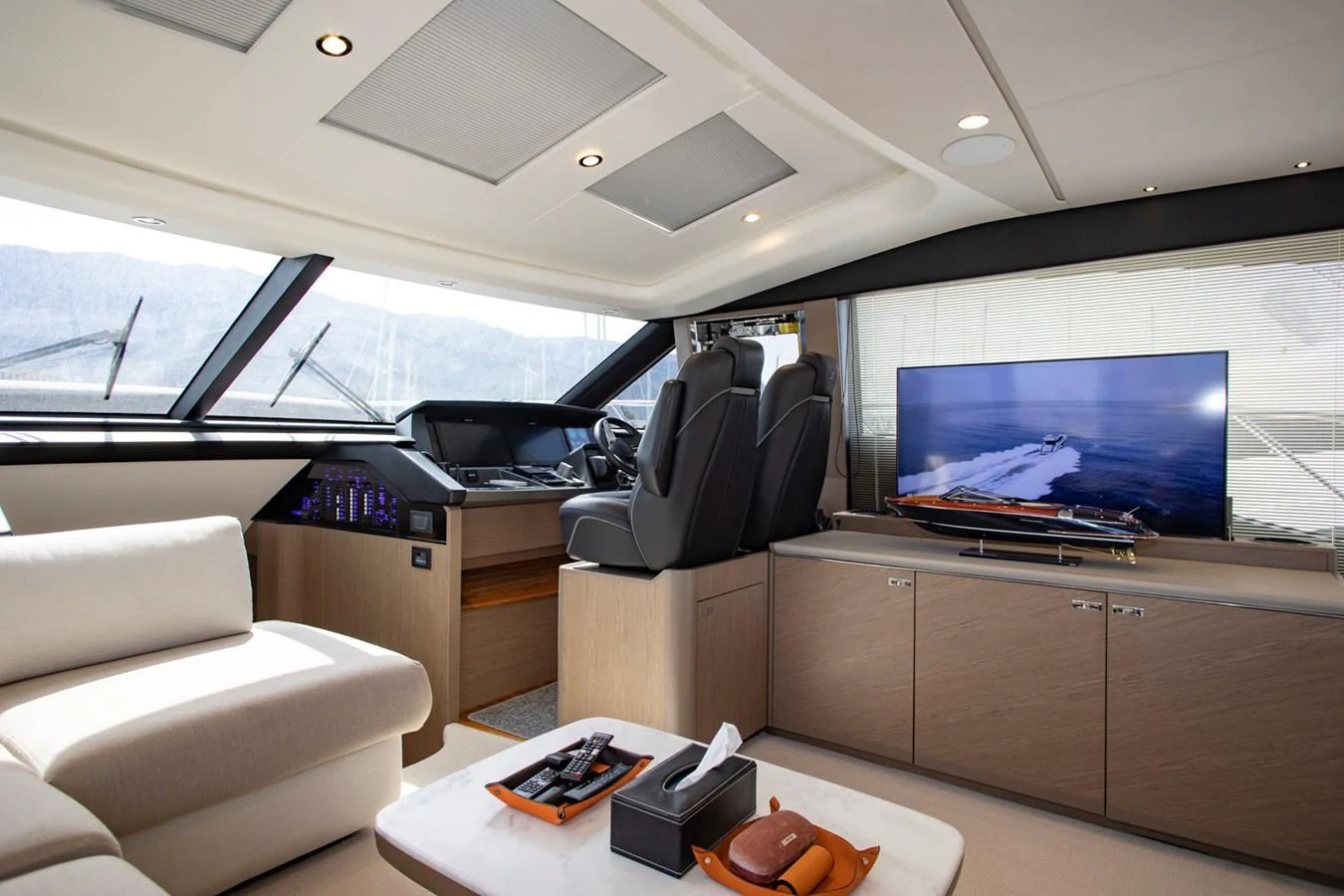 The helm area features a comfortable seating arrangement with a modern entertainment system. aboard BK ONE Yacht for Sale