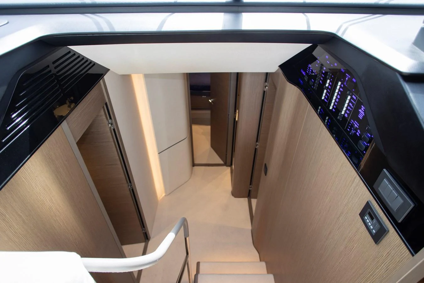 A sleek and modern staircase leads to the lower deck of the yacht, showcasing elegant wood finishes and ambient lighting. aboard BK ONE Yacht for Sale