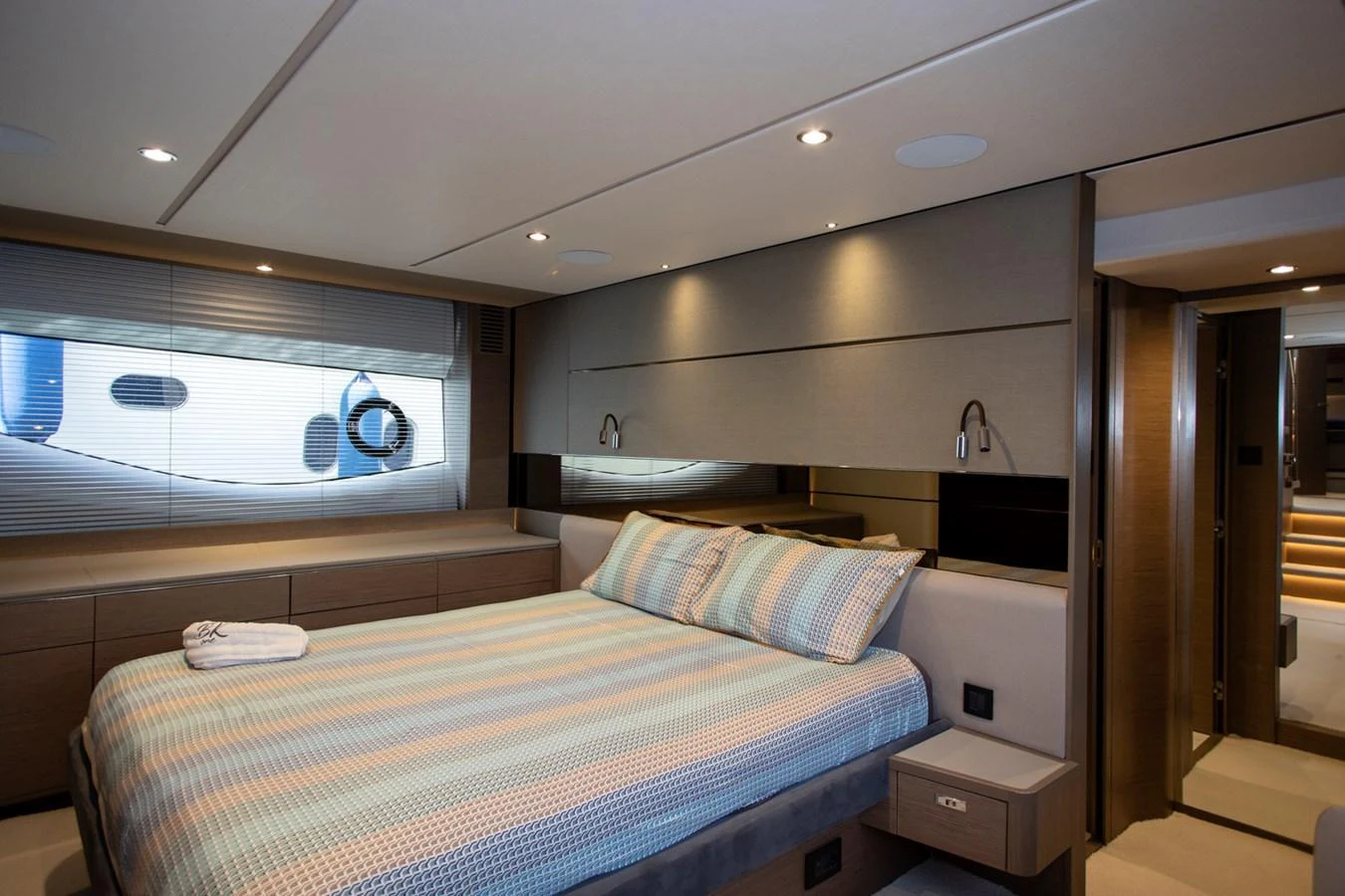 The stateroom features a comfortable bed with modern decor and ample natural light. aboard BK ONE Yacht for Sale