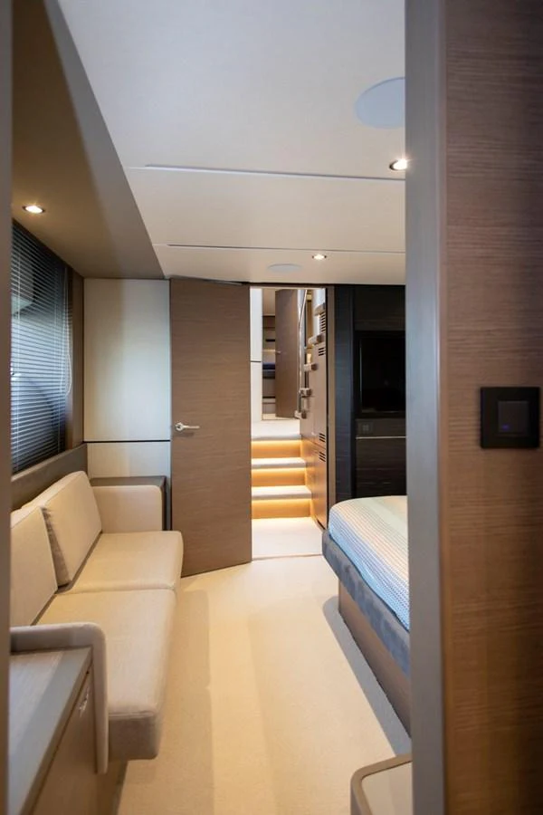 A cozy stateroom featuring a comfortable seating area and a bed, with warm lighting and modern finishes. aboard BK ONE Yacht for Sale