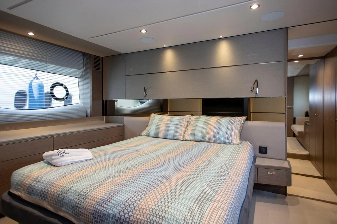 The stateroom features a comfortable bed with modern decor and ample natural light. aboard BK ONE Yacht for Sale