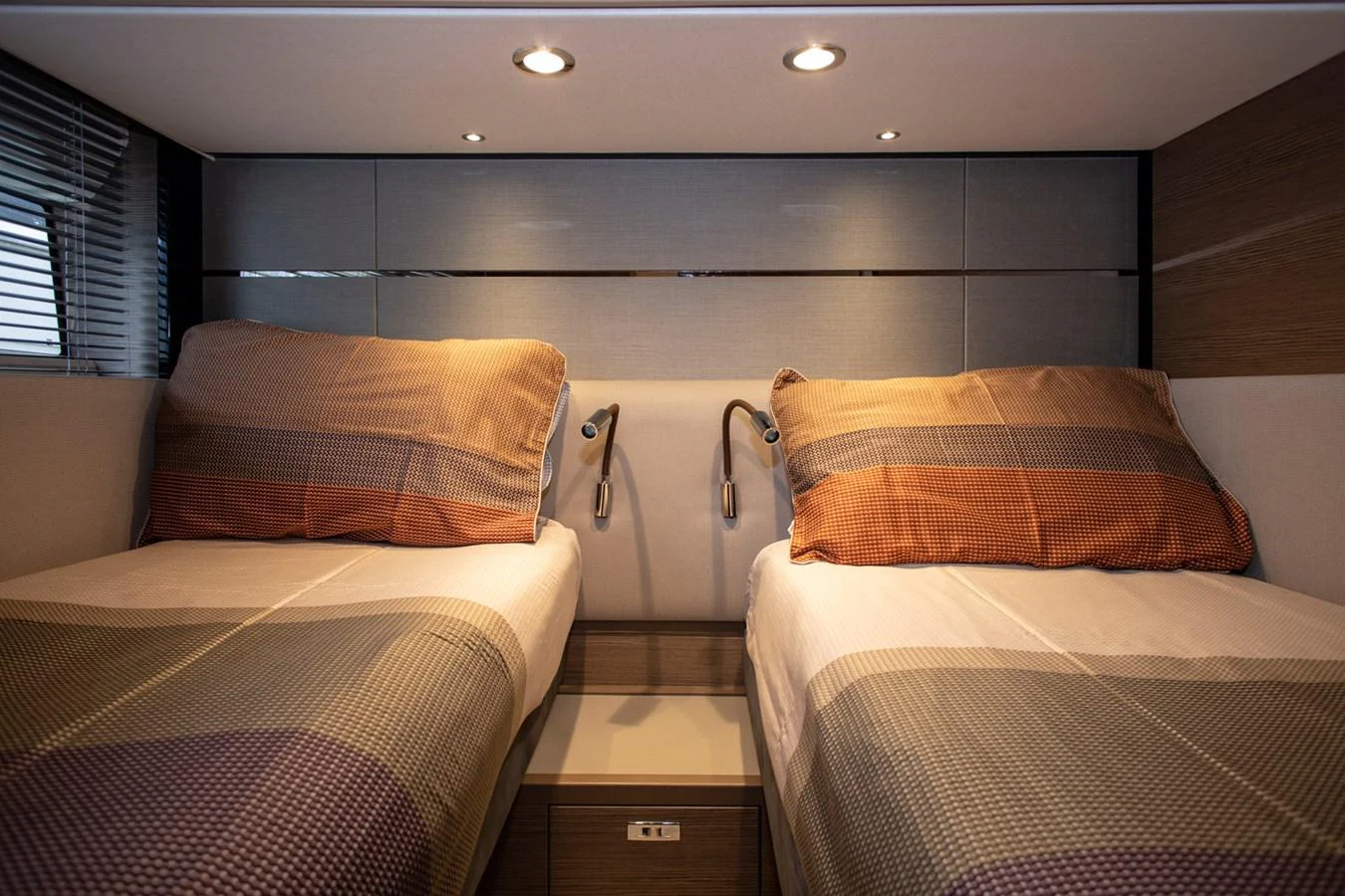 The twin stateroom offers a cozy and modern sleeping area with two single beds and ambient lighting. aboard BK ONE Yacht for Sale