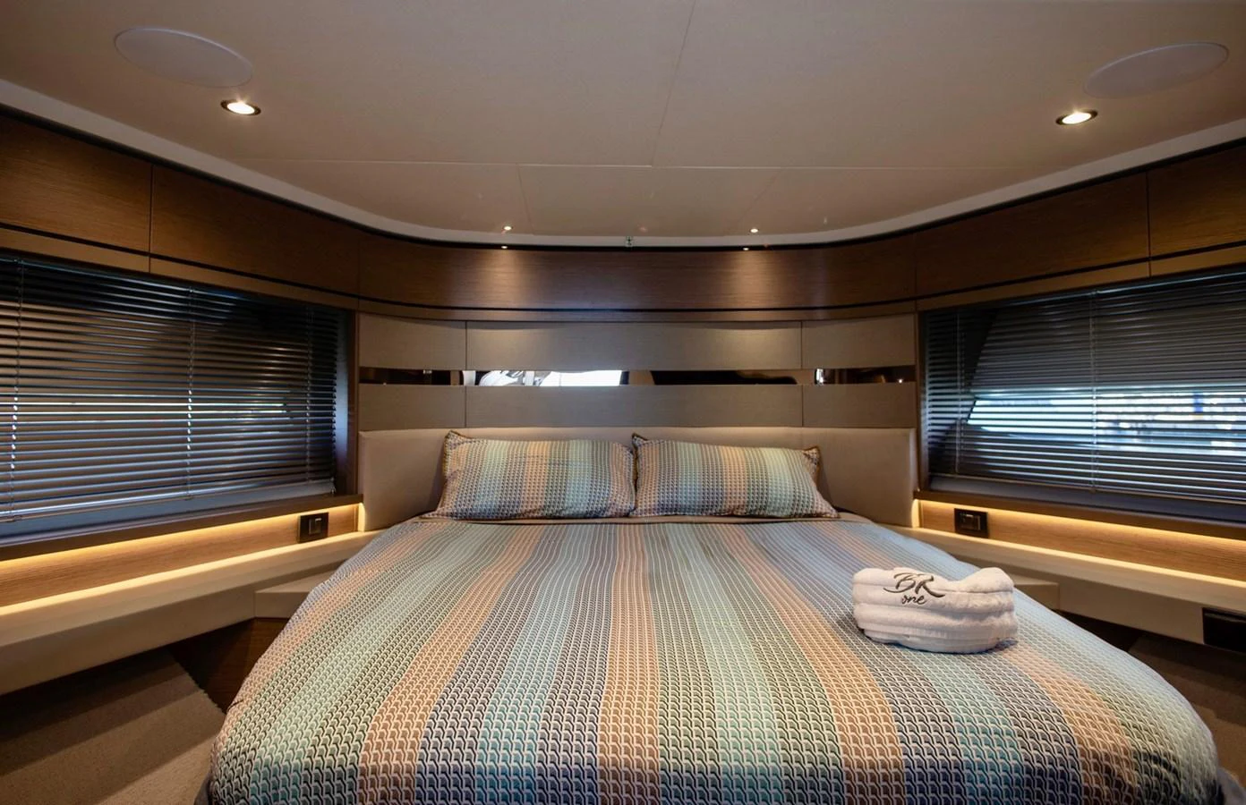 The stateroom features a spacious bed with elegant bedding and modern lighting. aboard BK ONE Yacht for Sale