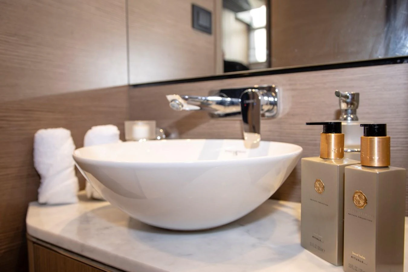 The image showcases a luxurious bathroom sink area with elegant toiletries and a modern faucet. aboard BK ONE Yacht for Sale
