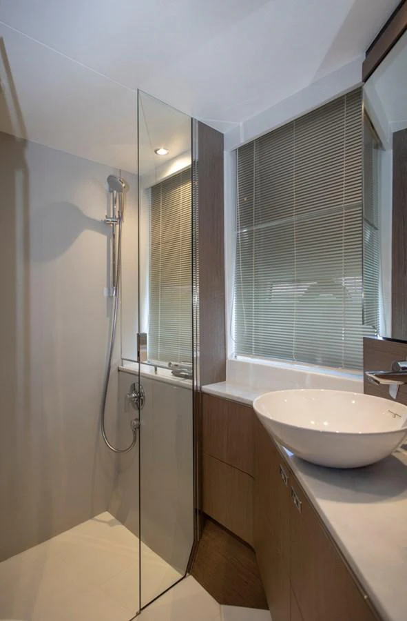 A modern yacht bathroom with a glass-enclosed shower and sleek fixtures. aboard BK ONE Yacht for Sale