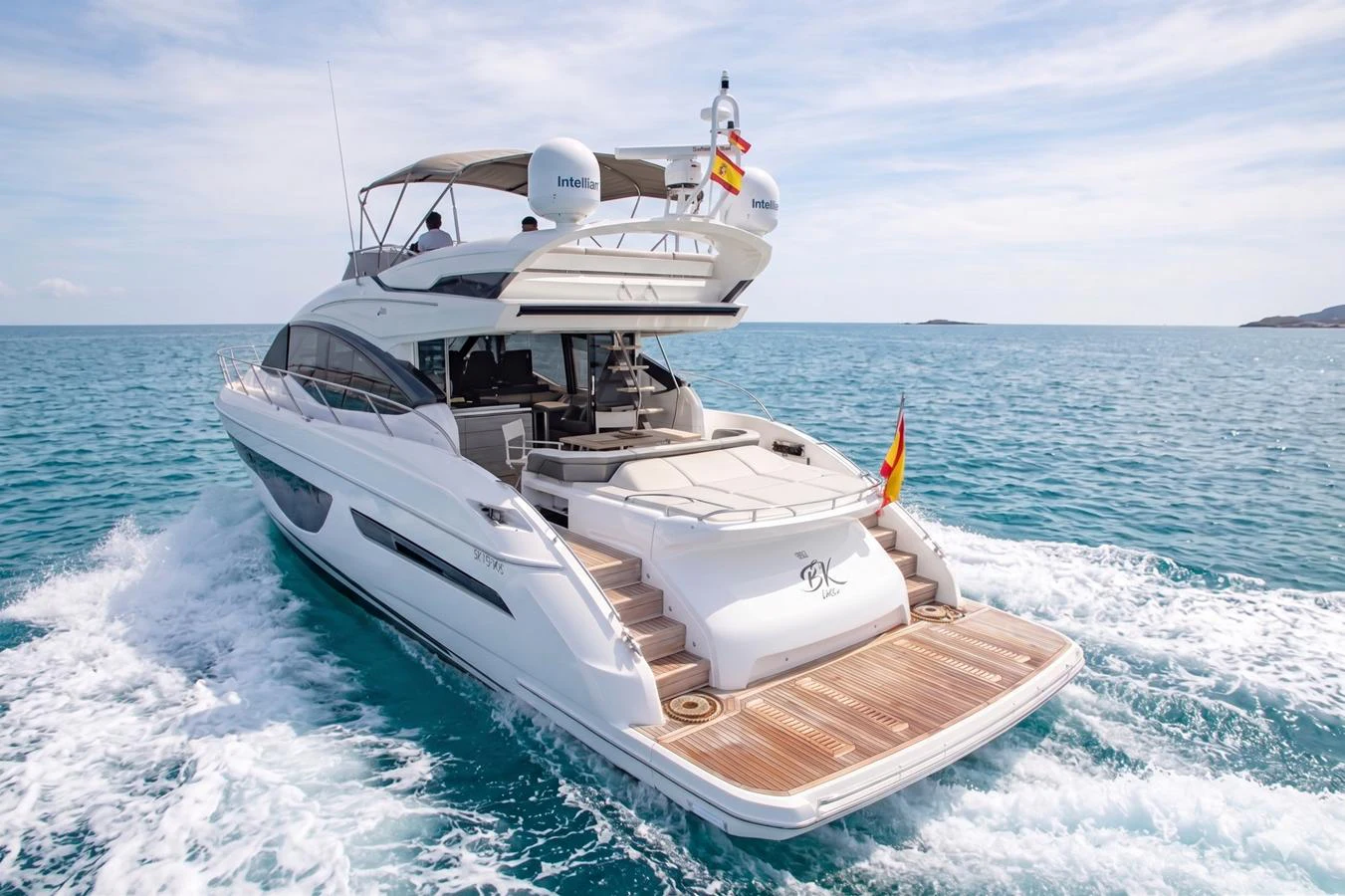 A sleek and modern yacht cruises through clear blue waters, showcasing its elegant design and spacious aft deck. aboard BK ONE Yacht for Sale