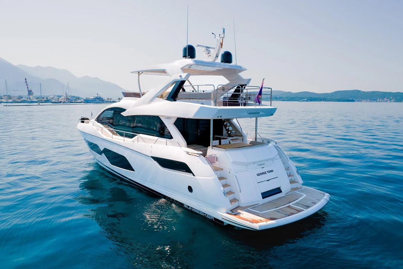 A sleek and modern yacht cruising on calm waters with a clear view of the aft deck and upper deck. aboard SUNSEEKER 76Y Yacht for Sale