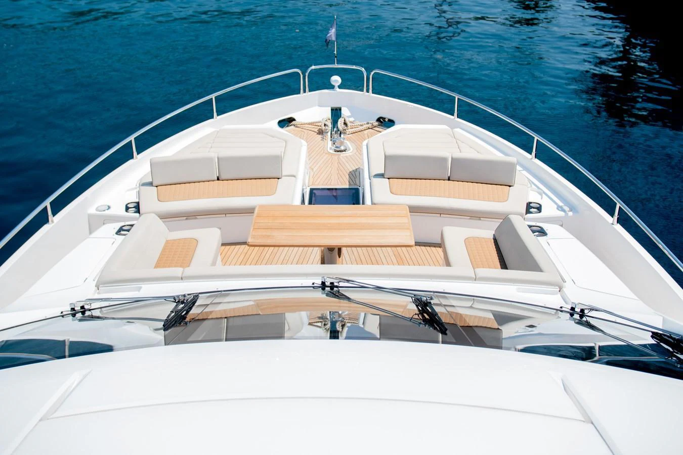 The foredeck features plush seating and a wooden table, perfect for relaxation and socializing. aboard SUNSEEKER 76Y Yacht for Sale