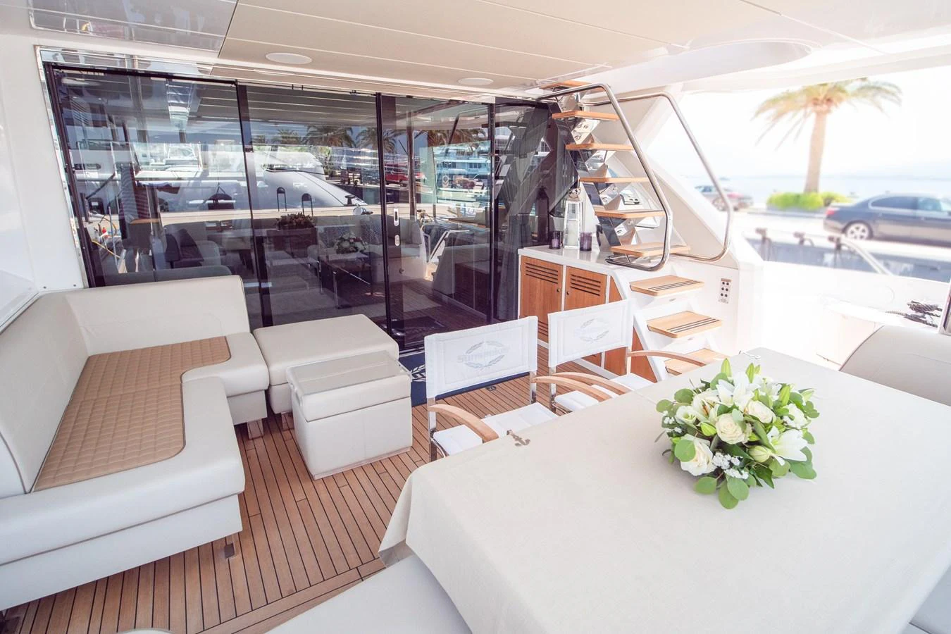 The aft deck features elegant seating and a dining area with a view of the marina. aboard SUNSEEKER 76Y Yacht for Sale