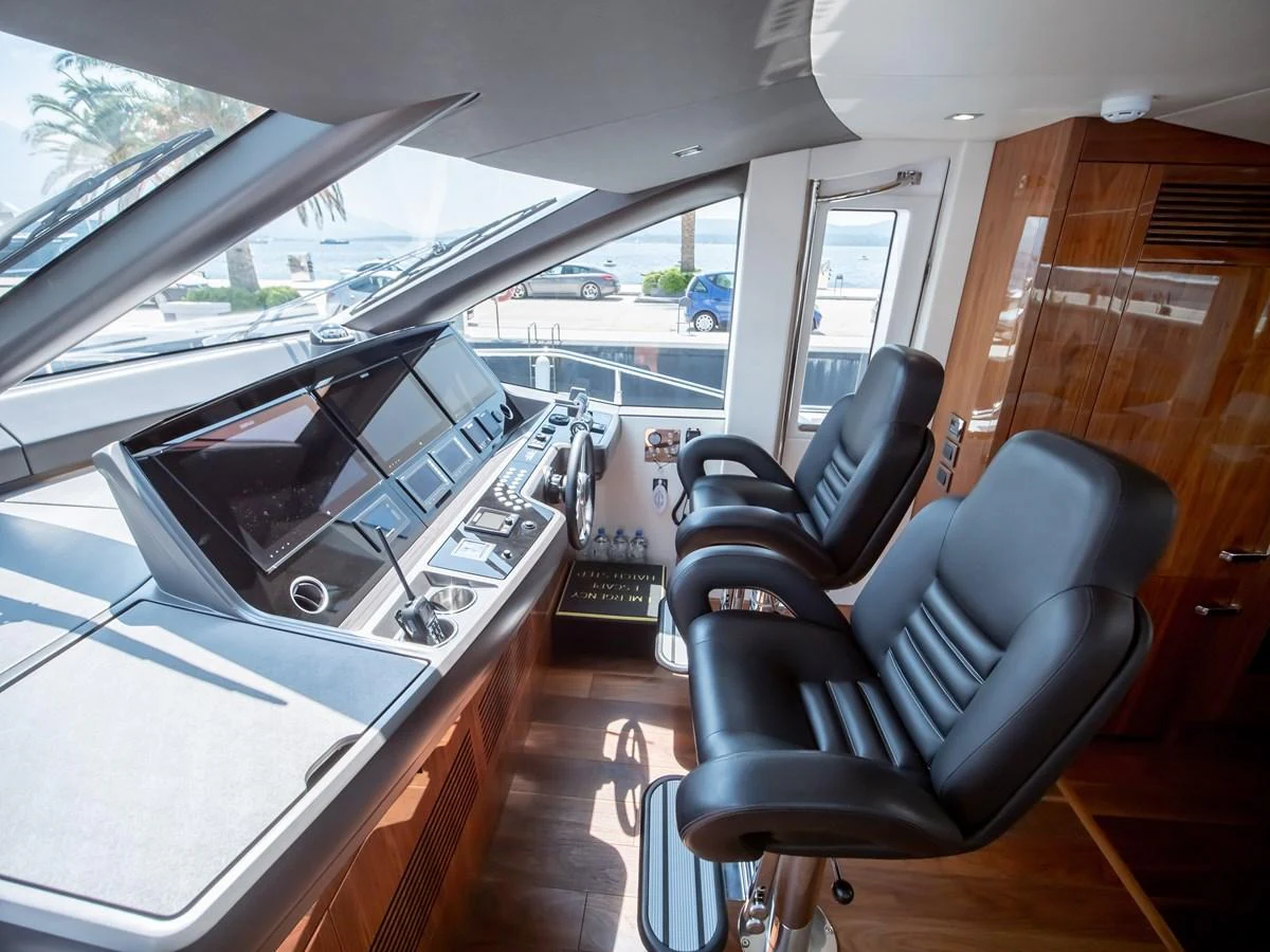 The helm station features modern navigation equipment and comfortable seating with a view of the surroundings. aboard SUNSEEKER 76Y Yacht for Sale